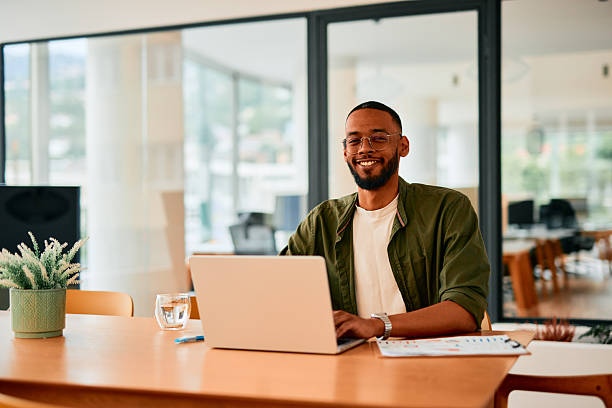 istock Young businessman smiling and working on laptop in modern office 2222963848