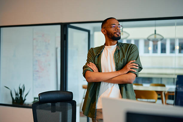 istock Confident young manager standing with arms crossed in modern office 2222963852