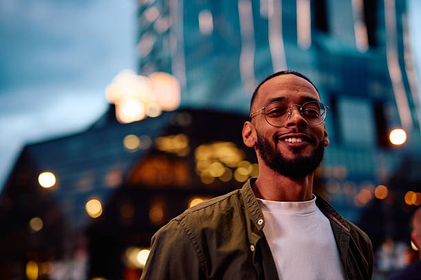 istock Young man smiling in the city at dusk 2222964034