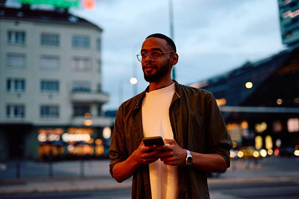 istock Young man using smartphone in city at dusk 2222964035