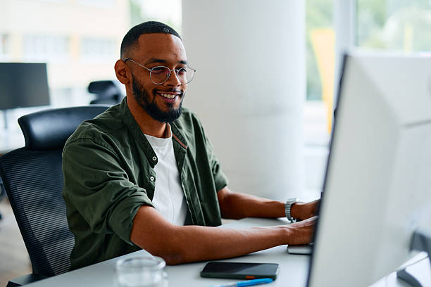 istock Smiling young businessman working on computer in modern office 2222964036