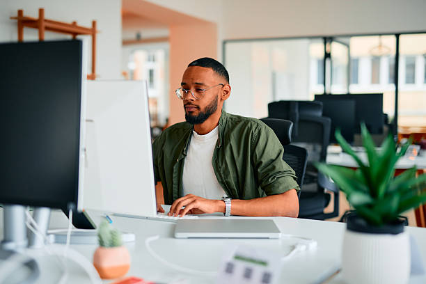 istock Focused young businessman working on computer in modern office 2222964039