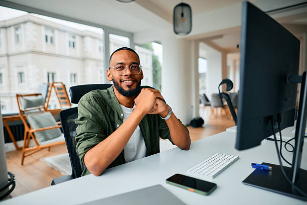 istock Young businessman smiling at the camera while working in the office 2222964174