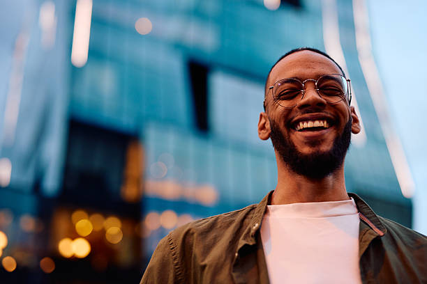 istock Young black man smiling in front of modern building 2222964281