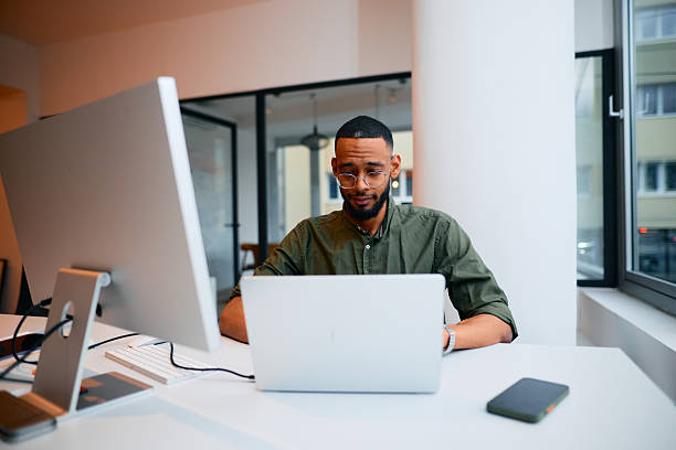 istock Focused young businessman working on laptop in modern office 2222964325