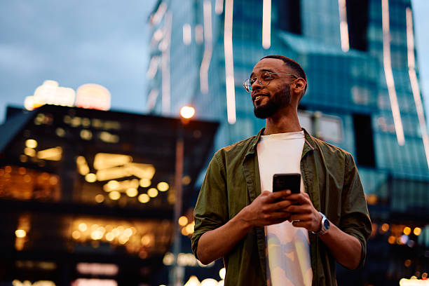 istock Young man using smartphone in urban city night setting 2222964483