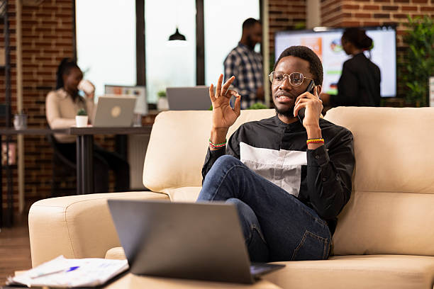 istock Businessman making phone call on couch 2222966480