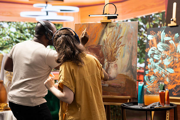 istock Talented artist and her apprentice applying watercolor paint on canvas 2222969309