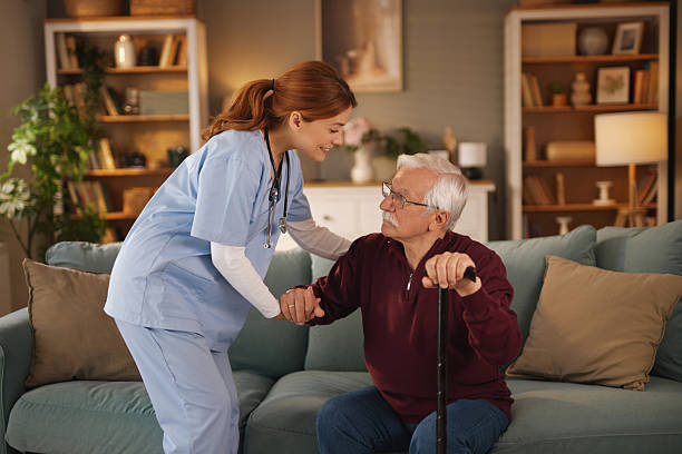 istock Nurse helping senior man getting up from sofa at home 2222969476