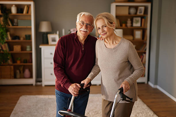 istock Senior couple smiling and holding walking frame at home 2222969645