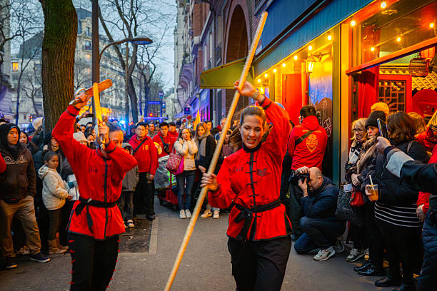 Two local French performers take part in a martial arts demonstration during the Lunar New Year celebrations in Paris’s 13th arrondissement, drawing attention from spectators on both sides of the street.