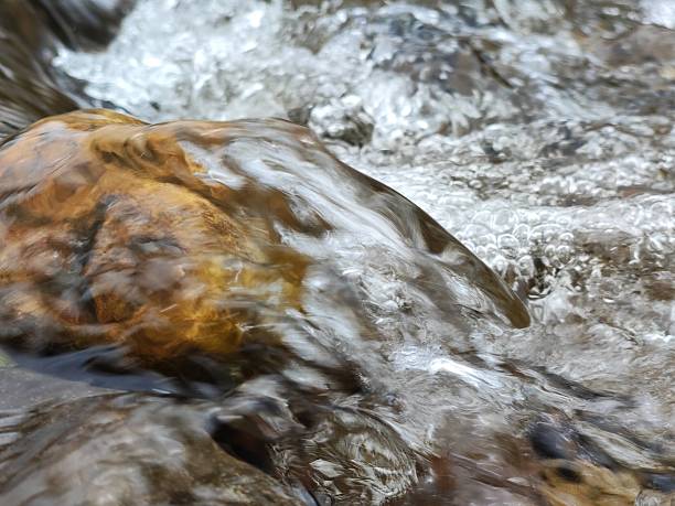 Water flowing over a rock in a river, South Wales UK.
