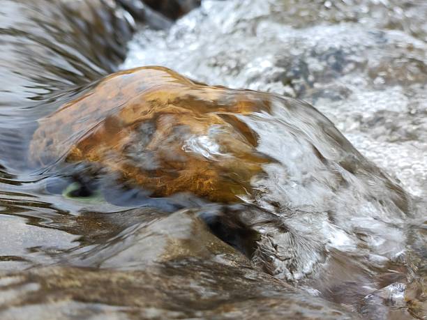 Water flowing over a rock in a river, South Wales UK.