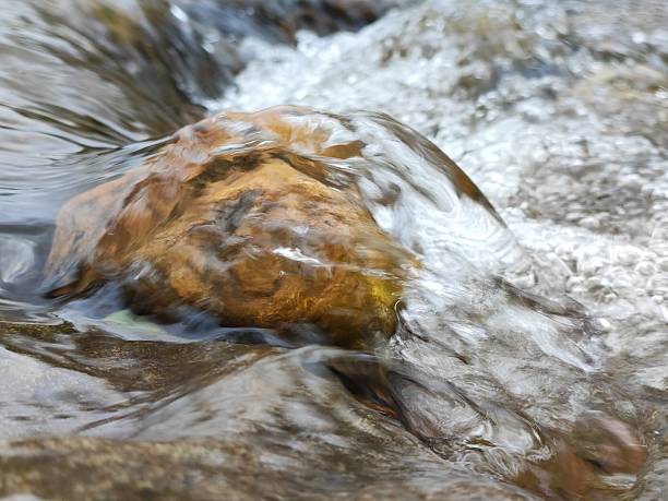 Water flowing over a rock in a river, South Wales UK.