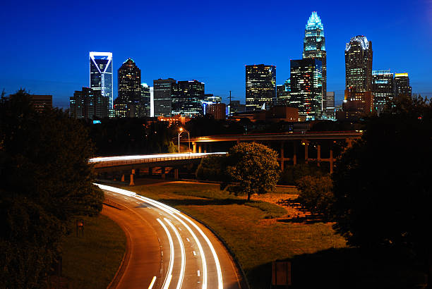 Charlotte, NC, USA May 29, Cars Travel on the highway as the lights of the Charlotte skyline is illuminated at night