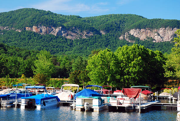 Lake Lure, NC, USA May 29 Boats are moored at a dock with a scenic view of the mountains and forest in Lake Luew, North Carolina