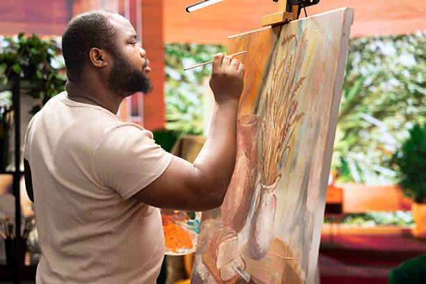 istock African american artist using his skill to paint a new creation in art studio 2222981335