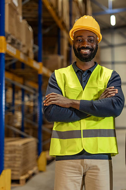 istock Confident Warehouse Worker Smiling in Safety Gear Standing in Storage Area 2222982898