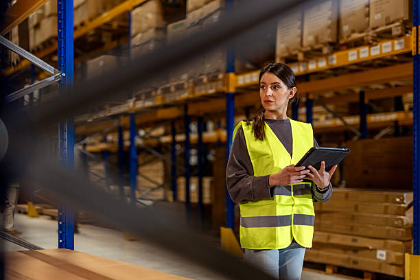 istock Female Worker Inspecting Warehouse Inventory Using a Tablet in a Storage Facility 2222982940