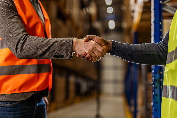istock Businessmen Shaking Hands in Warehouse While Collaborating on Industrial Projects 2222983028