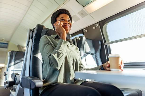 istock Businesswoman Talking on Phone While Traveling by Train With Coffee 2222983086