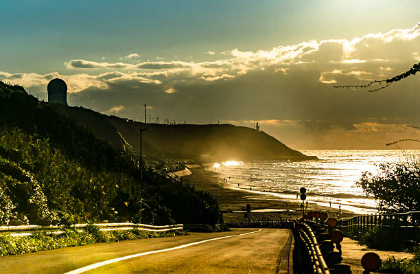 A straight road along the sea at dawn.