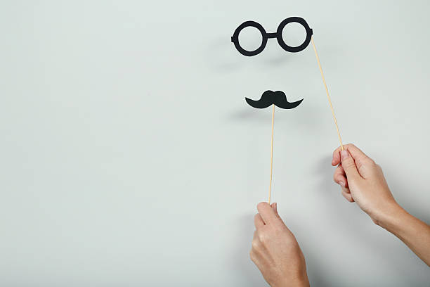 istock Female hands holding paper booth props on grey background 2222996565