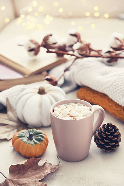 istock Cup of coffee with pumpkins, dry leafs and knitted sweaters 2222998787