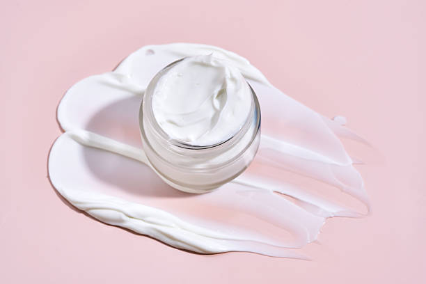 istock An open jar of cream with its texture on a pink background. 2223009807
