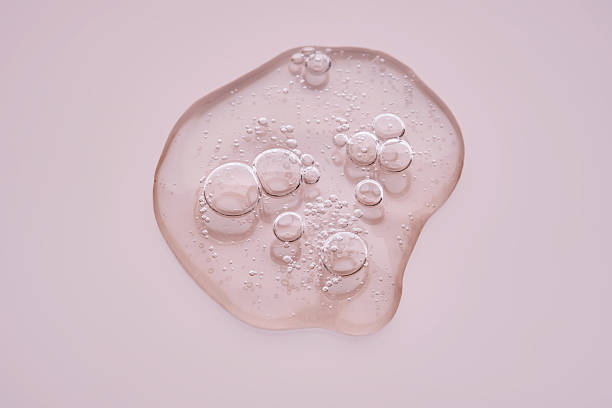 istock Textured drop of serum with bubbles on pink background. 2223010474