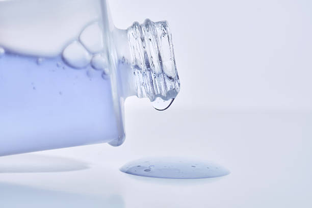 istock A cosmetic bottle from which a blue emulsion is poured. 2223013208