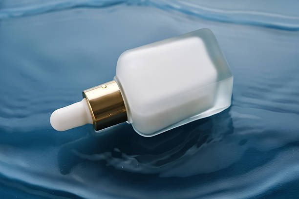 istock Bottle with white moisturizing serum in water on blue background. 2223013433