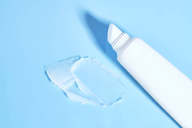 istock White lip balm in a tube on a blue background. The texture. 2223013637