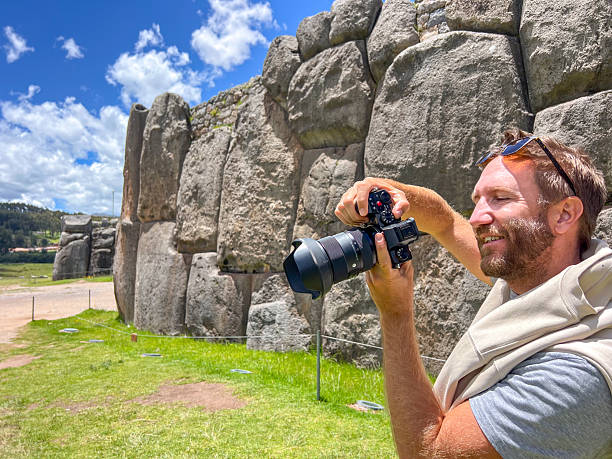 istock Smiling man holding camera and taking photo near ancient stone wall 2223016866