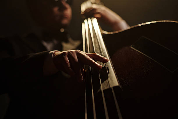 istock Middle Aged Caucasian Man Plucking Upright Bass Strings during Jazz Performance 2223019234