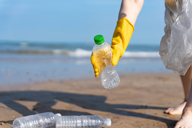 istock Coastal Cleanup Volunteer Picking Up Plastic Bottle 2223019510