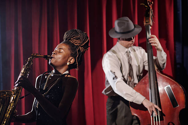 istock Young Female Musician Playing Saxophone While Caucasian Man Performing Jazz 2223020467