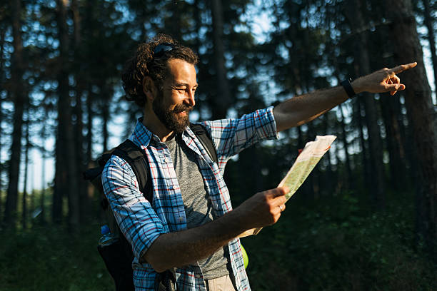 istock Adventurous Solo Hiker Exploring Nature with Map Pointing a Way 2223020576