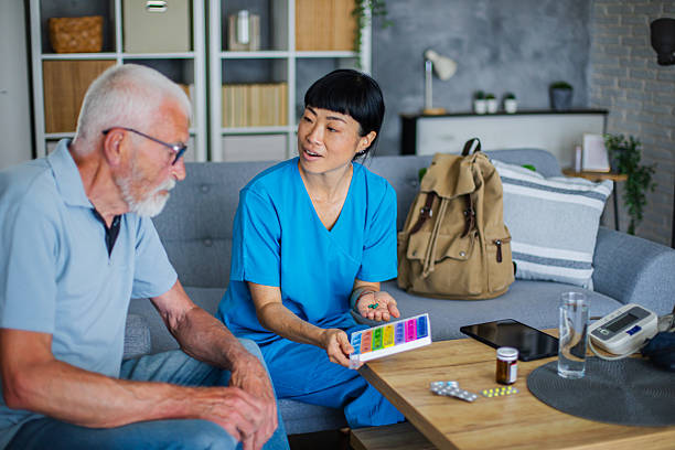 istock Friendly Healthcare Professional Helping Senior with Pill Organizer 2223021714
