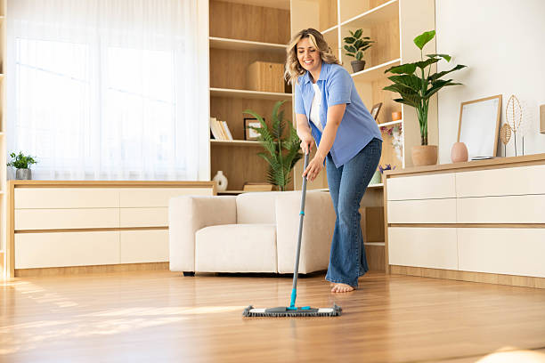 istock Joyful Woman Sweeping Floor at Home 2223028816