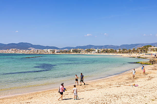 Mallorca, Spain-April, 2025: View at a sand beach with walking people a sunny day in Mallorca