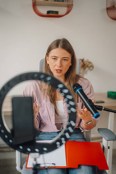 istock Young woman recording a podcast in her home studio using a ring light and a microphone 2223029792