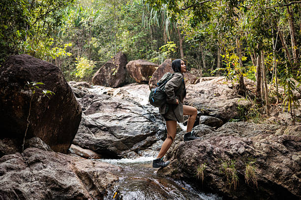 istock Young woman jumps over a river in the forest 2223030259