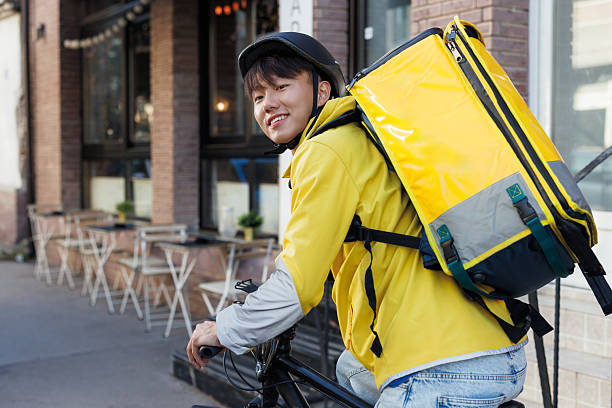 istock Young deliveryman with yellow backpack in an urban setting 2223030454