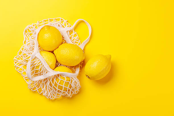 istock Fresh juicy lemons in a mesh bag, flat lay style 2223032753