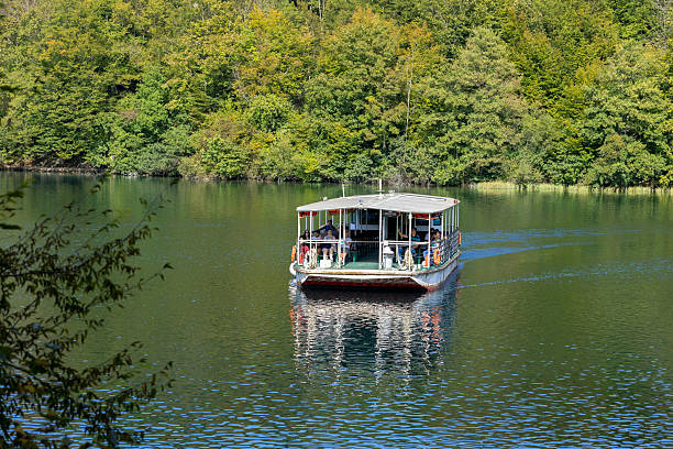 Plitvice Lakes, Croatia - September 22, 2024: Tourists on sightseeing boat, autumn view of Plitvice Lakes National Park