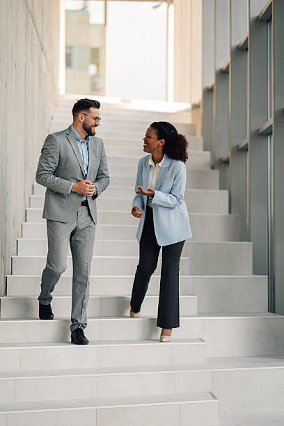 istock Businesspeople walking and talking on office stairs during a break 2223035592