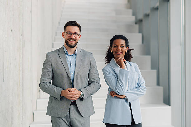 istock Two confident business professionals smiling on stairs in office 2223035632