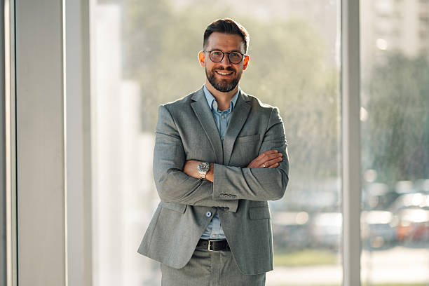 istock Confident businessman smiling with folded arms in modern office 2223035976