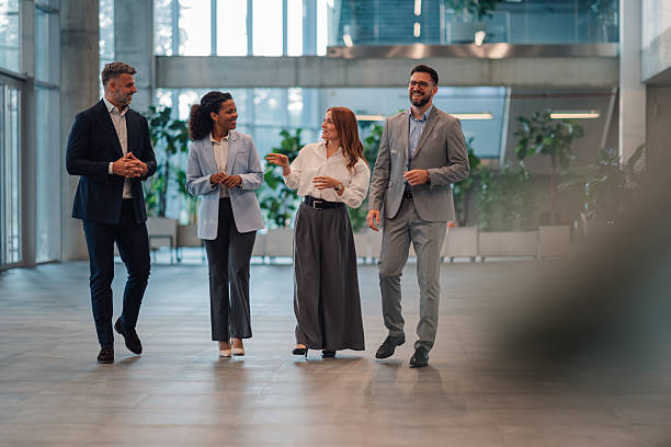 istock Businesspeople walking and talking in modern office building lobby 2223036176